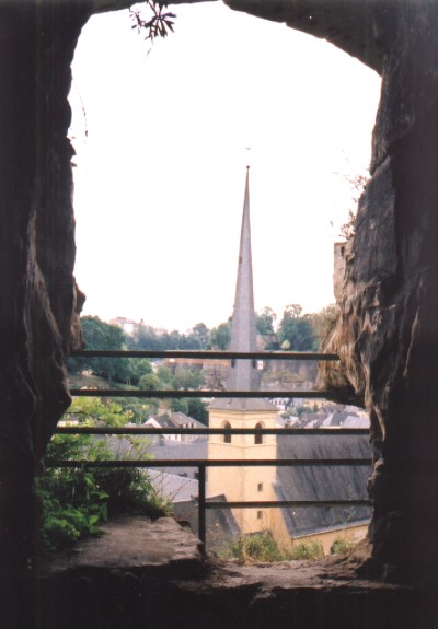 A view of a church spire through a gap in the rocks of the Bock Casemates