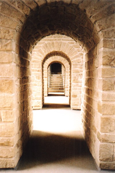A series of golden coloured stone arches leading to the exit of the Casemates